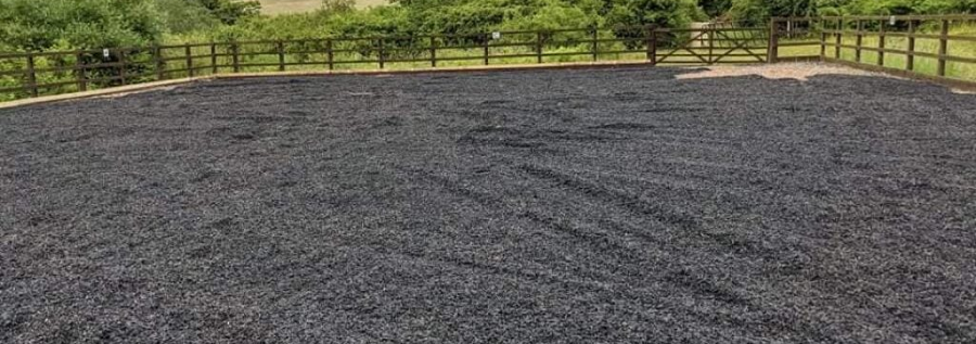 Freshly laid rubber chippings in an equestrian paddock