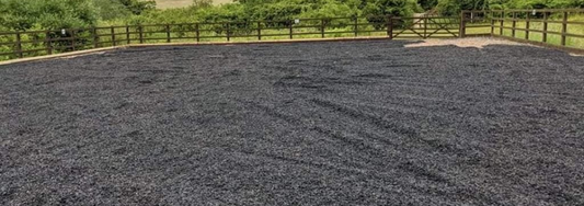 Freshly laid rubber chippings in an equestrian paddock