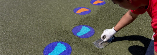Man laying wet pour in a children's playground